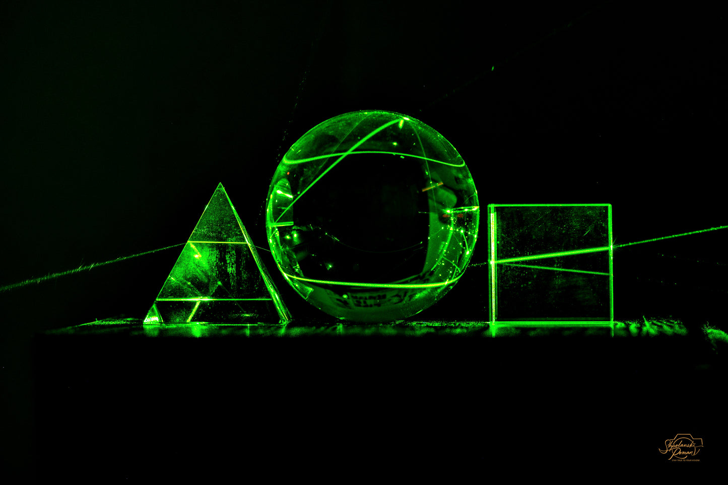 A glowing green laser arch and circle in darkness