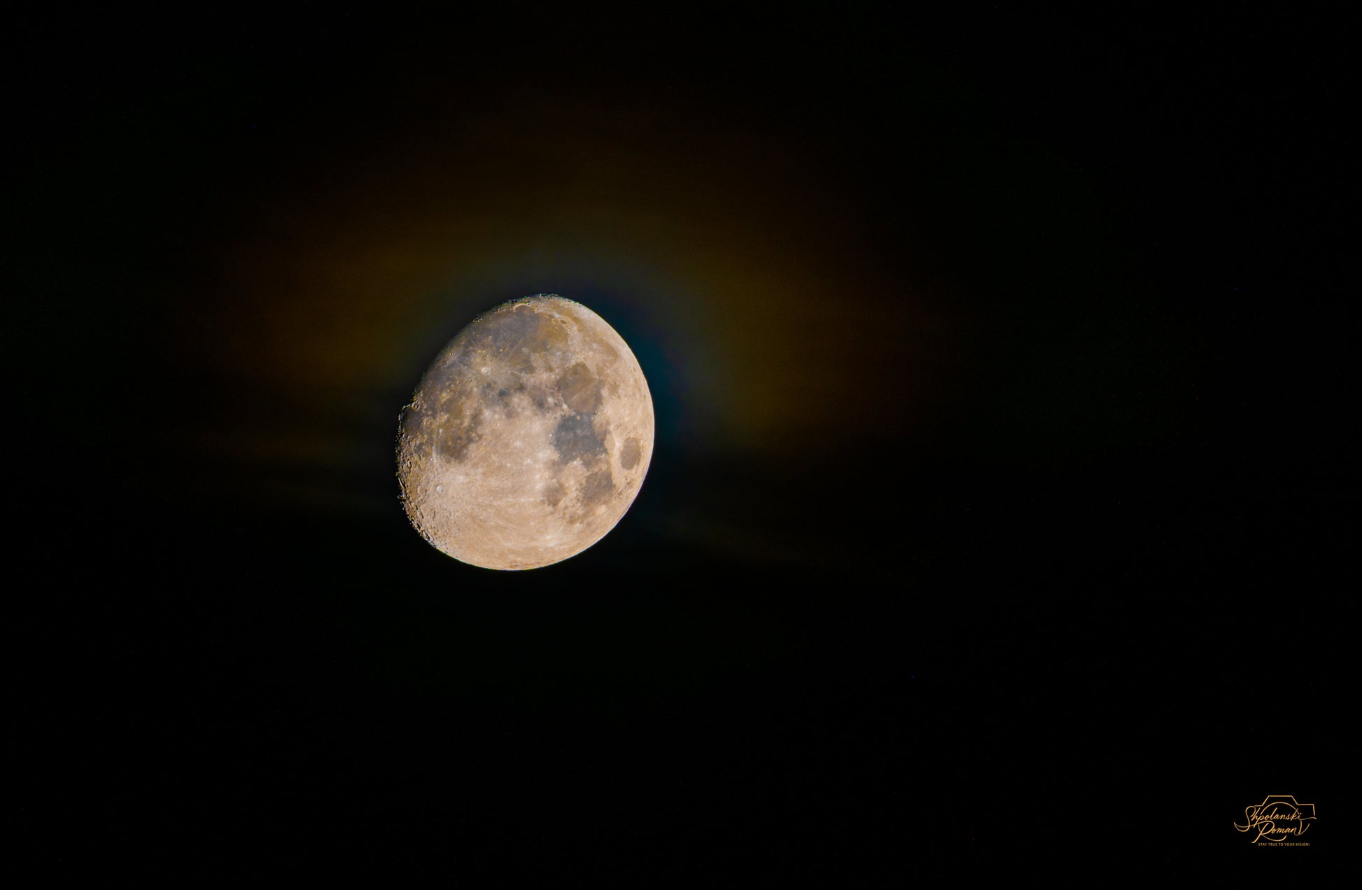 The moon ringed by a golden rainbow halo