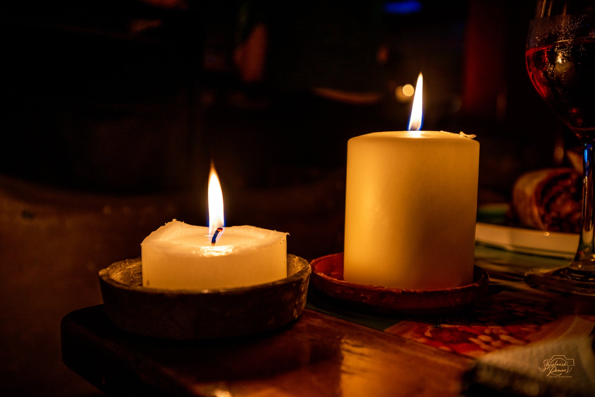 Two candle flames glowing in the dark