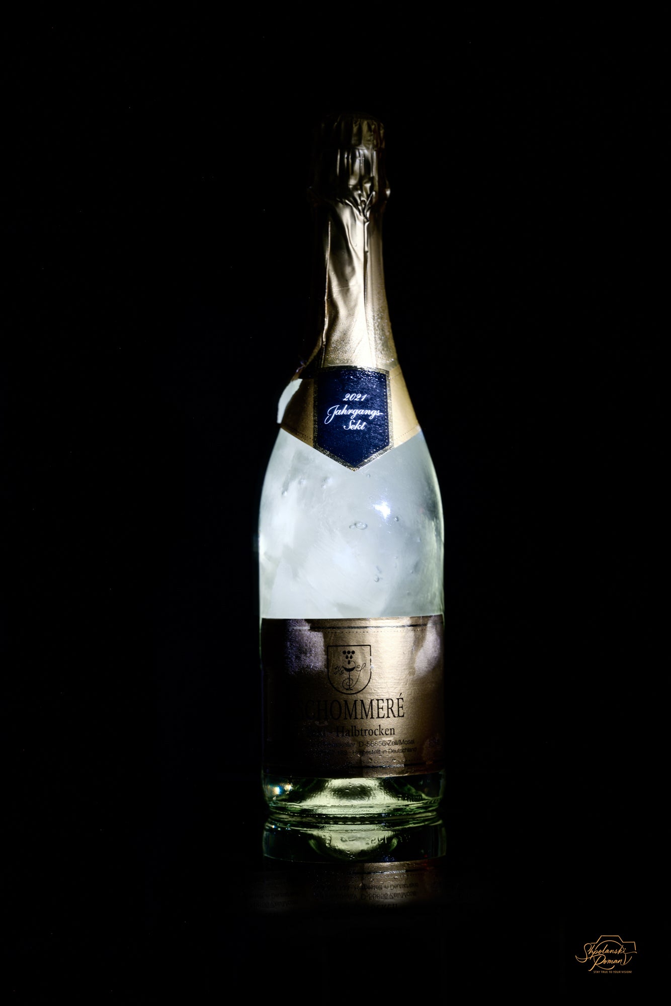 A bottle of sparkling wine against a black background