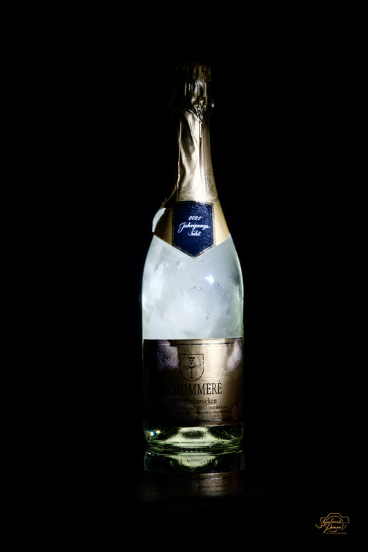 A bottle of sparkling wine against a black background