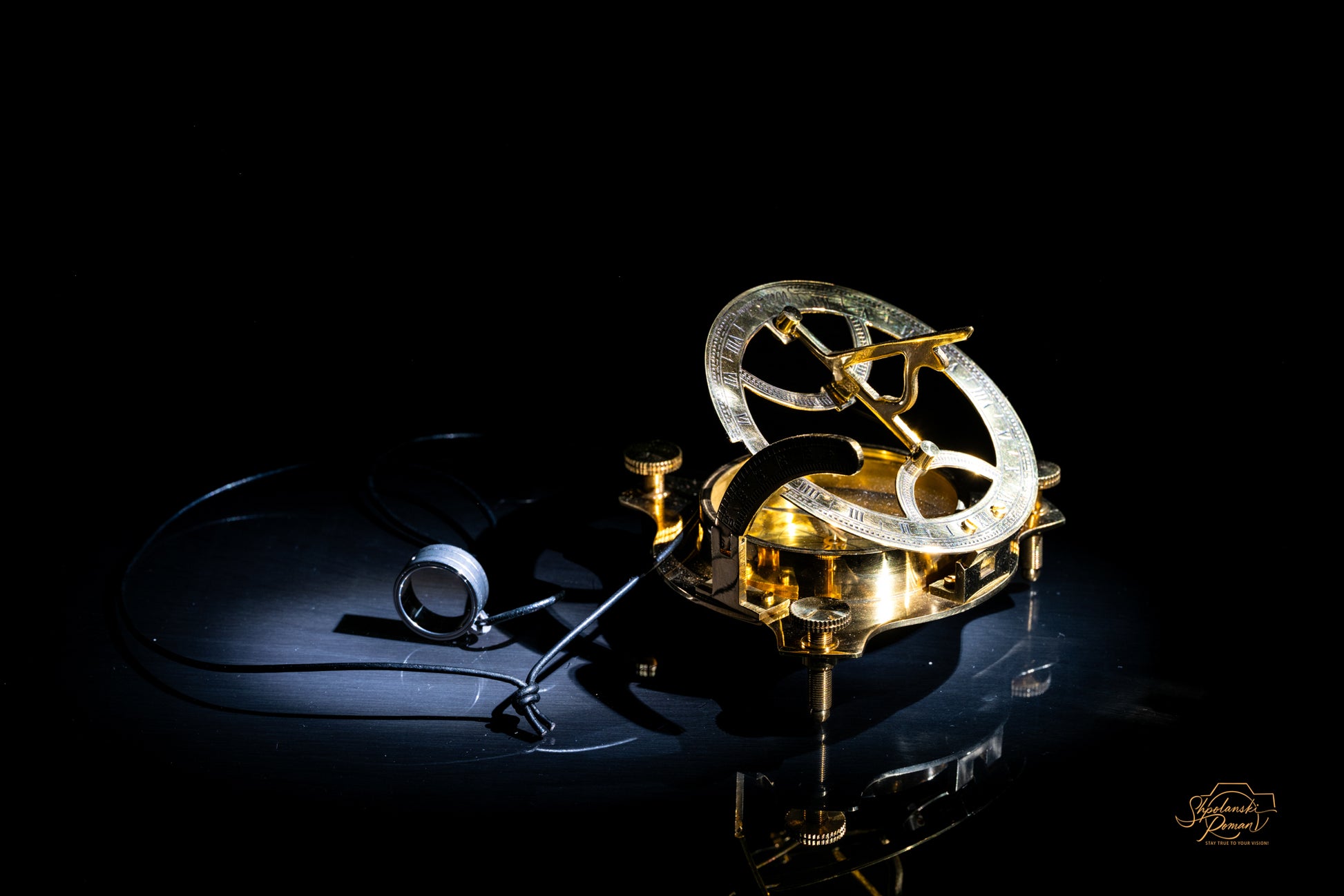 An antique golden pocket watch catching light on black