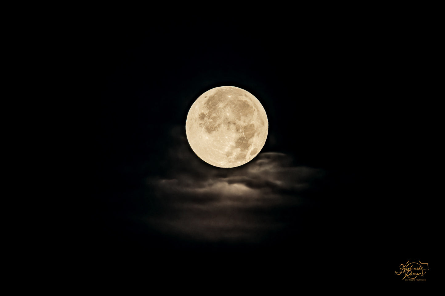 A full moon breaking through clouds at night